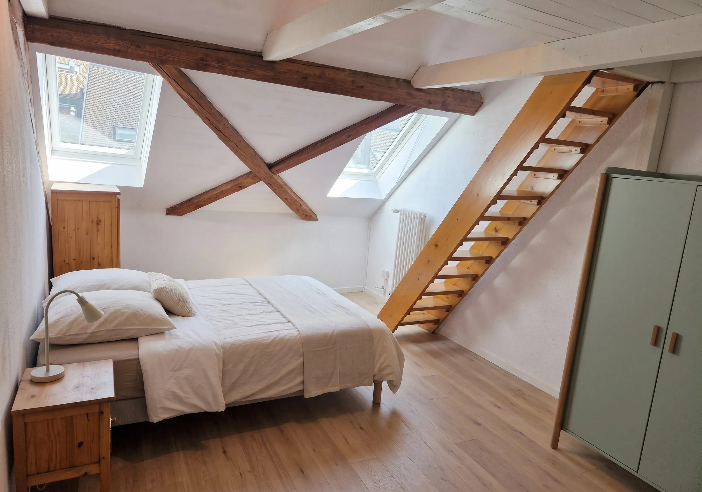 Chambre sous charpente avec escalier vers la mezzanine